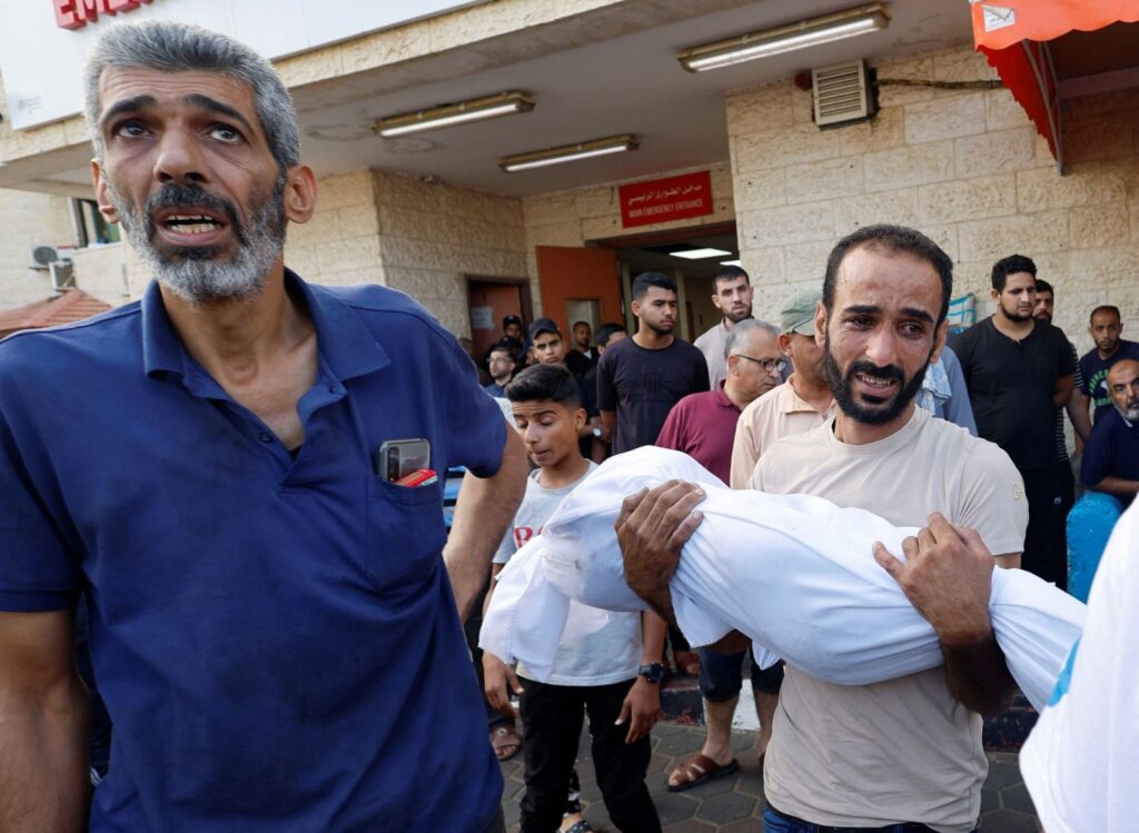 Foto: Seorang pria Palestina membawa jenazah seorang anak yang tewas dalam serangan Israel di sebuah rumah sakit, di Jalur Gaza tengah, 5 November. (REUTERS/Mohammed Salem)